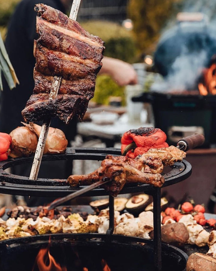 wagyu-beef-back-ribs auf einem Spieß, mit Gemüse und Beilagen auf dem Grill