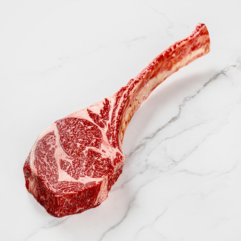 Wagyu Tomahawk Steak mit Knochen auf weißem Hintergrund, intensive Marmorierung, Hochwertiges Fleisch