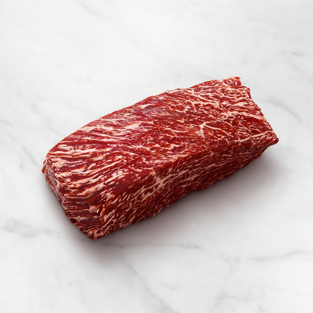 Bavette Steak schneiden und vorbereiten, Wagyufleisch auf einem weißen Teller, stark marmoriert, Wagyu Flap Steak